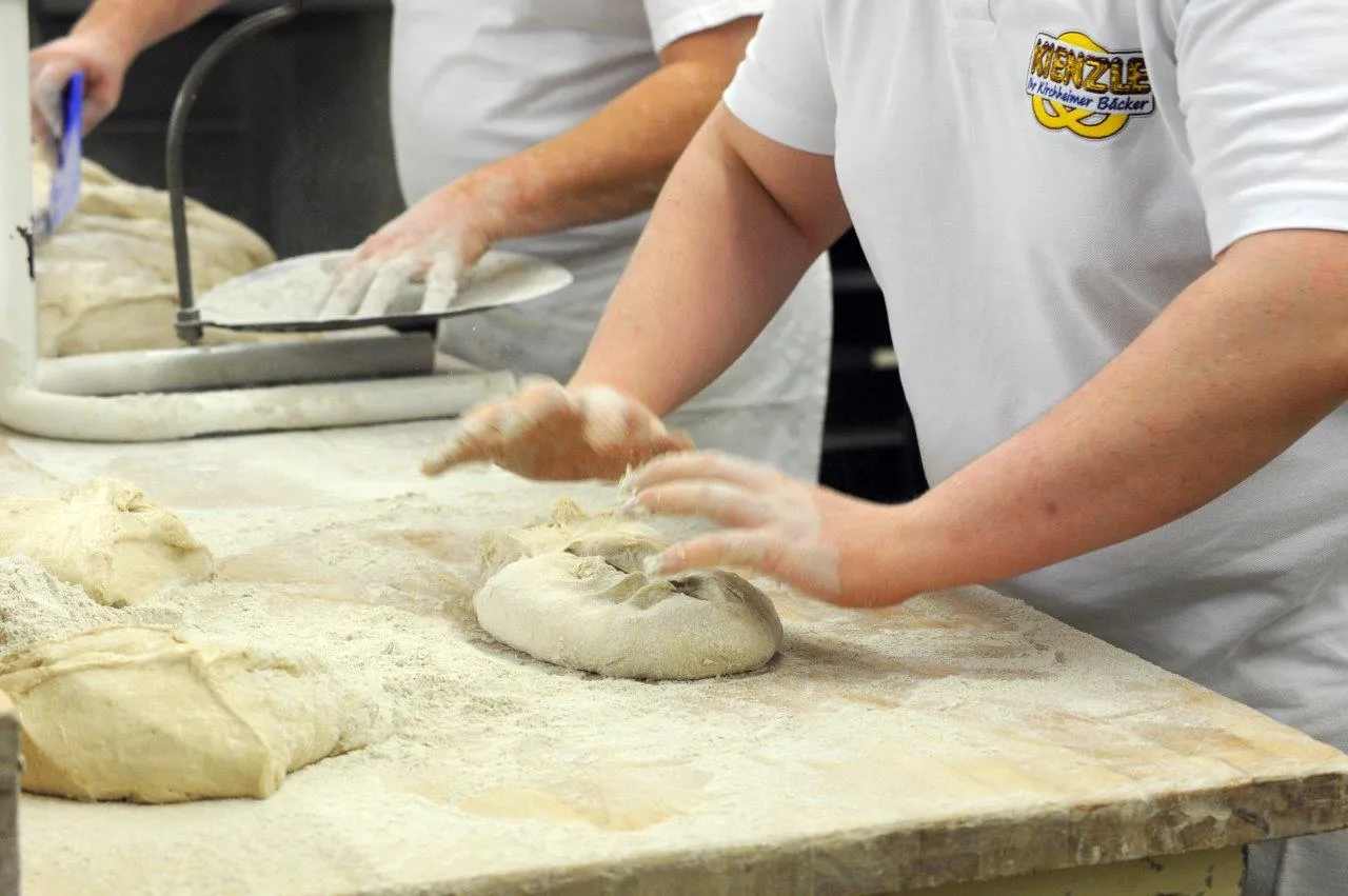 Ein Bäcker formt einen Brotlaib von Hand